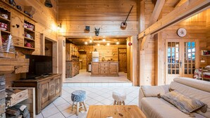Ein Holzblockbau-Innenraum mit Wohnbereich, Küche und einem gemütlichen Kamin.