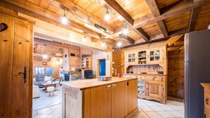 Ein Interieur einer Holzhütte mit Küchenbereich, Holzausbau und einer zentralen Kochinsel.