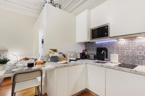 Eine moderne Küche mit weißen Schränken, einer Mikrowelle, einem Spülbecken und einer gestreiften Spritzschutzwand.