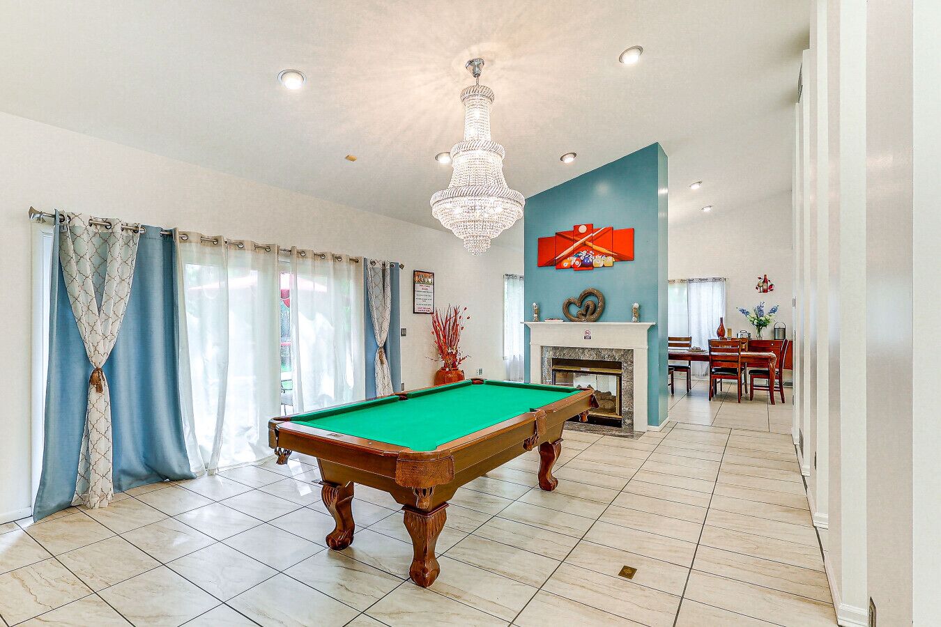 Ein geräumiges Zimmer mit Pooltisch, Kamin und Essbereich.