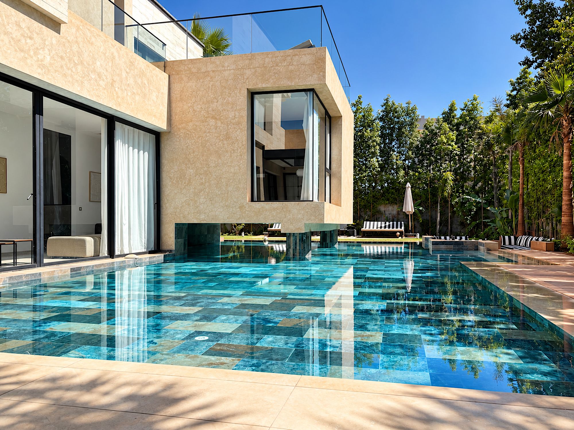 Zona de piscina moderna amb aigua cristal·lina, gandules i vista a un edifici amb grans finestres.