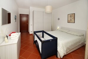 Un dormitorio con cama, cuna, armario y espejo.