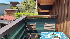 A wooden deck with a table and chairs, a small pool, and a view of neighboring houses. - o\tSelf-contained studio in house 3 km from Annecy town center, (Seynod)