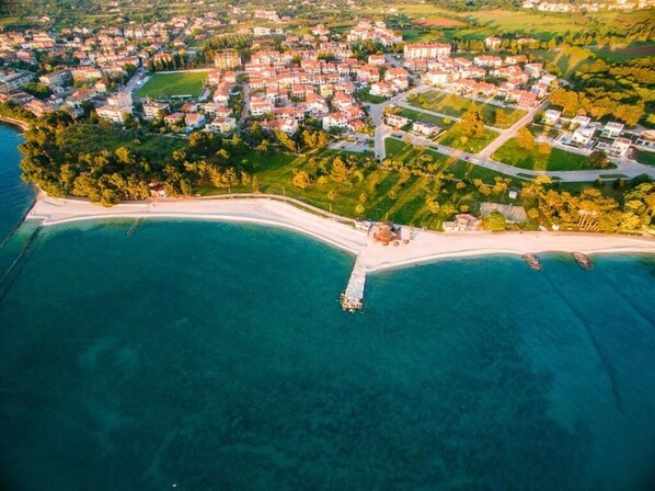 An aerial view of a coastal town with a marina, residential areas, and a beach.