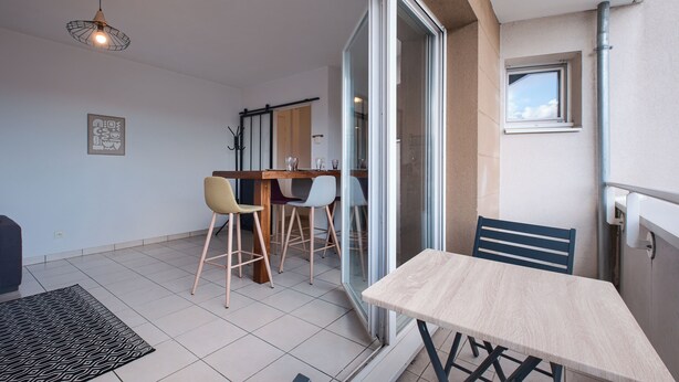 A dining area with a table and chairs, a ceiling light, and a window. - La Grange - Proche Centre & Parking (Laval)