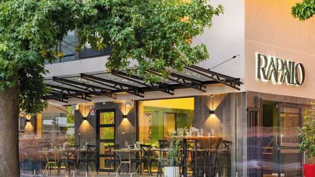 Un restaurante con terraza, una pérgola y un letrero que dice 'RAPALO'.