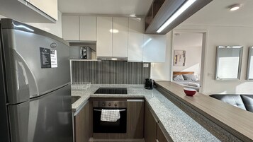 B4 Depto Single | Cozinha privada | Geladeira grande, micro-ondas, fogão, cooktop