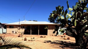A desert landscape with a house, cactus plants, and palm trees. - Centrally located Tucson home, renovated 2 bedroom/1 bath home. (Tucson)