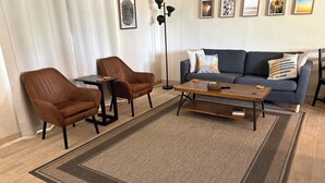 A living room with a sofa, two armchairs, a coffee table, and a rug. - Centrally located Tucson home, renovated 2 bedroom/1 bath home. (Tucson)