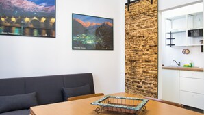 Een modern interieur met een bank, een eettafel en een keukenhoek.