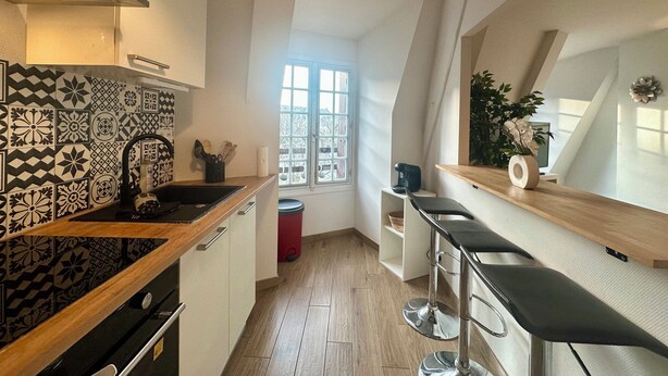 Una cocina moderna con baldosas estampadas, una encimera de madera, un fregadero y una ventana con vistas.