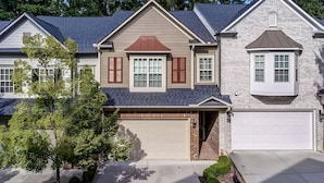 A two-story house with a garage, a covered front porch, and a brick exterior. - 3-bedroom townhome in adorable Mableton. Close to all the charms of Atlanta. (Mableton)