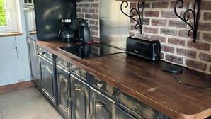 Una cocina con encimera de madera, electrodomésticos de acero inoxidable y salpicadero de ladrillo.