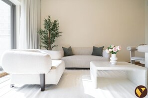 Luxury-Apartment, Balkon, Poolblick | Wohnbereich | 65-Zoll-Smart-TV mit Kabelempfang