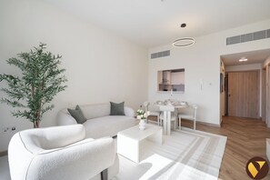 Luxury Apartment, Balcony, Pool View | Living area | 65-inch Smart TV with cable channels - Vogue | Jeewar JVC near Circle Mall | Pool & Gym (Dubai)