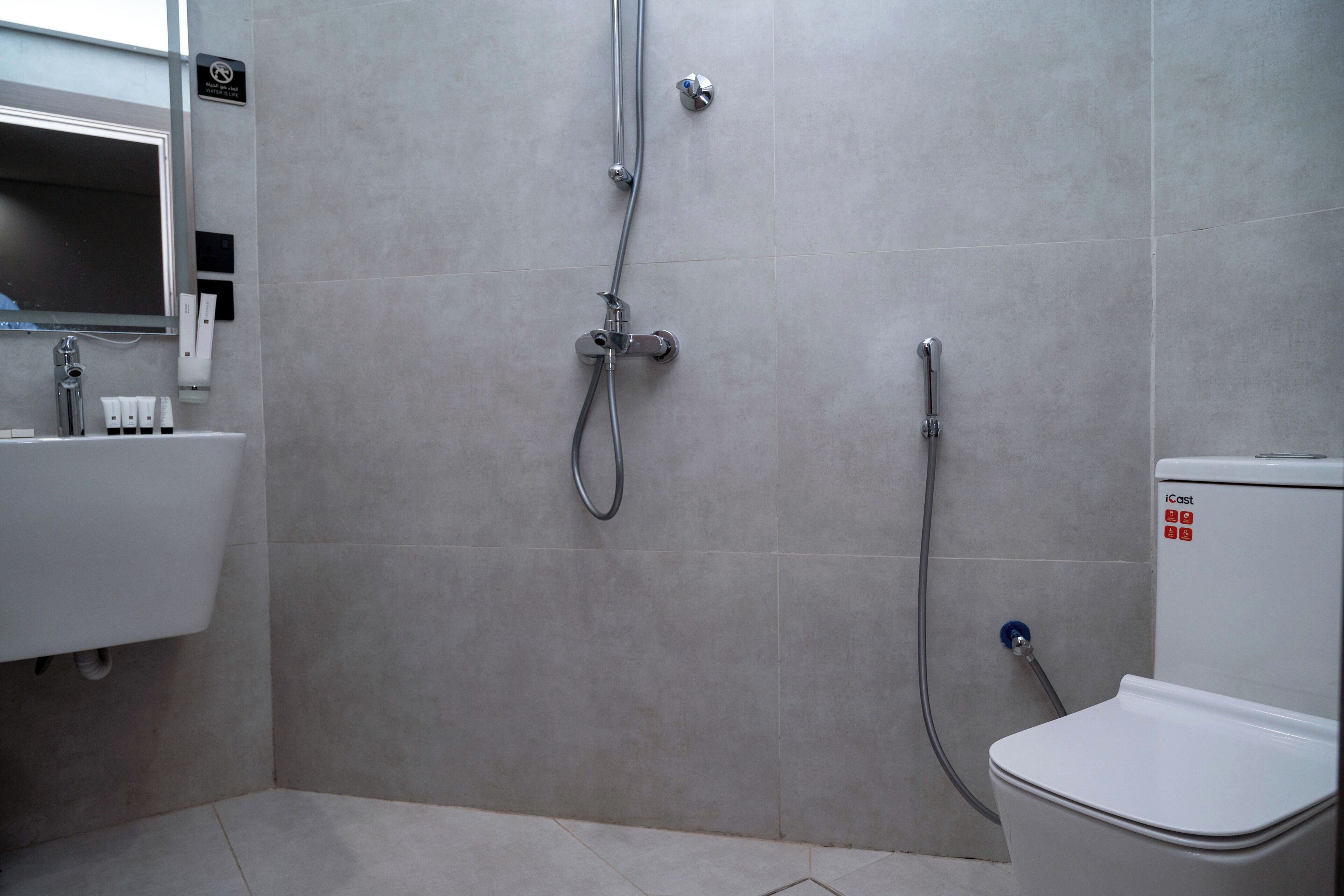 A modern bathroom with a toilet, sink, and shower.