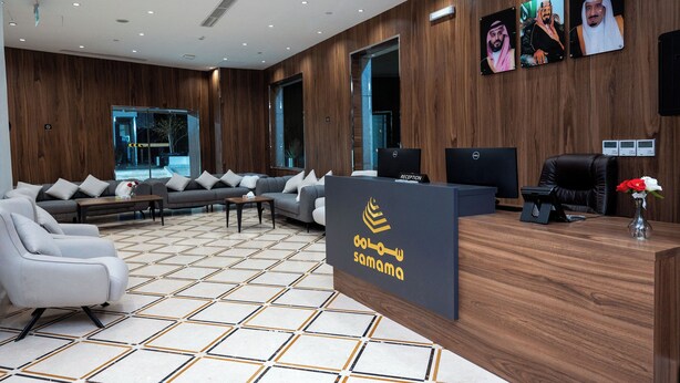 A reception area with a modern design, featuring a reception desk, seating area, and large windows. - Samama Almaqam Hotel - Ajyad ( فندق سمامة المقام ) (Makkah)