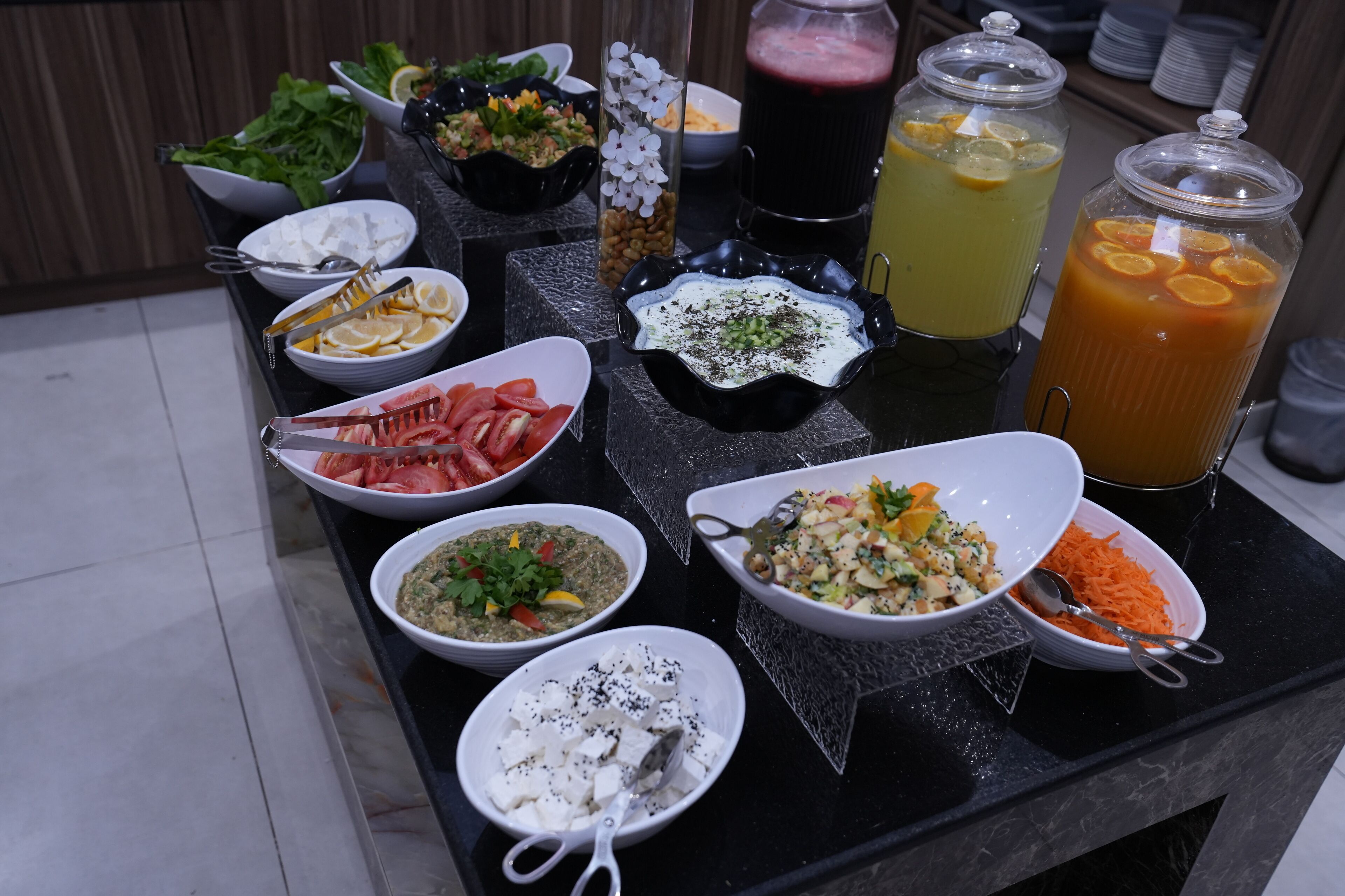 A buffet table with various dishes and drinks.