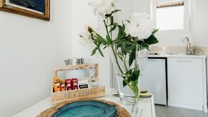 A kitchen with white cabinets, a sink, and a countertop. There is a vase with white flowers on the counter. - Turquoise studio with AC in beautiful Budva perfect for getaway (Budva)