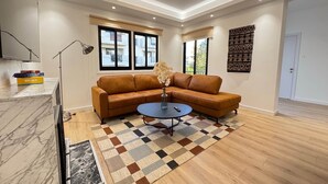 A modern living room with a leather sofa, a coffee table, and a patterned rug. - GameHouse in the City Center (Nicosia)