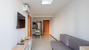 Eine moderne Wohnung mit Wohnbereich, Küchenzeile und Essplatz.
