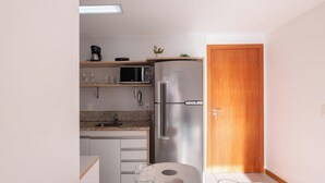 Eine kleine Küche mit Kühlschrank, Mikrowelle und Spüle.