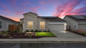 A modern two-story house with a stone facade, a well-maintained lawn, and a garage. - Private Bakersfield Getaway Near Downtown & Parks! (Bakersfield)