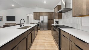A modern kitchen with a central island, stainless steel appliances, and wooden cabinetry. - Private Bakersfield Getaway Near Downtown & Parks! (Bakersfield)
