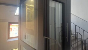A modern interior with a glass door leading to a balcony. - A Casa di Imma - Elegant studio apartment in Porta Rom (Milano)