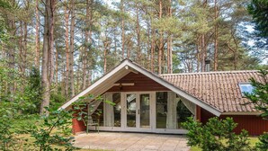A cabin with a sloped roof, large glass doors, and a stone patio. - 6 Person Holiday Home in Hadsund (Hadsund)
