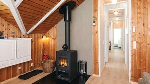 A wooden interior with a fireplace, white cabinets, and a wooden ceiling. - 6 Person Holiday Home in Hadsund (Hadsund)