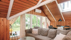 A cozy wooden interior with a sectional sofa, a round table, and a dining area. - 6 Person Holiday Home in Hadsund (Hadsund)