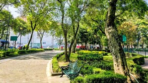 Un parc doté d’un sentier dallé, de bancs et d’une végétation bien entretenue.