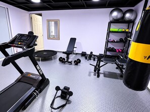 Et fitnesscenter med løbebånd, styrkemaskiner og boksebold.
