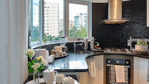 Una cocina moderna con una isla curva, ventanas amplias y un salpicadero negro.