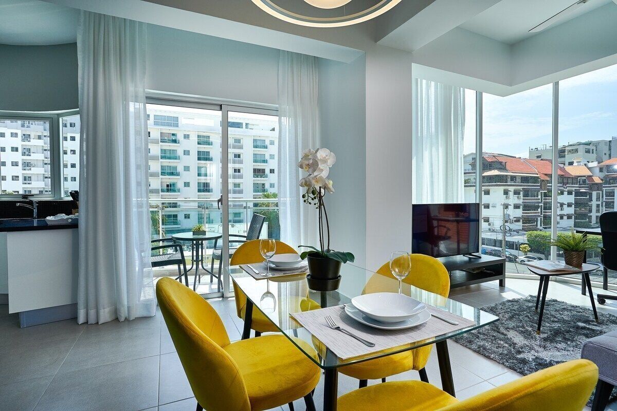 A modern apartment with a dining area, kitchen, and living space.