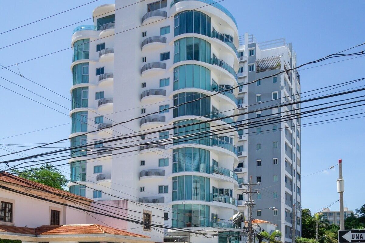 Um edifício com várias andares, varandas e janelas amplas.