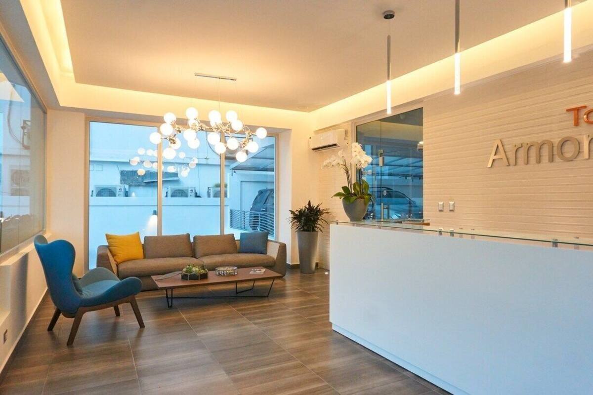 A modern reception area with a sofa, a coffee table, and a chandelier.