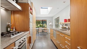 Una cocina moderna con armarios de madera, estufa a gas y tragaluz.