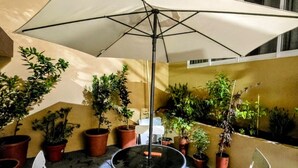 An outdoor patio area with a round table and two chairs, surrounded by potted plants. - Suite roja céntrica ideal para conocer la ciudad (Mexico City)