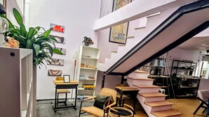 A modern interior with a staircase, wicker furniture, and a bookshelf. - Suite roja céntrica ideal para conocer la ciudad (Mexico City)
