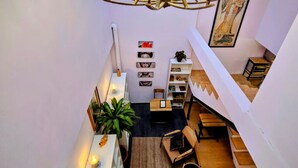 A modern loft apartment with a central staircase, a chandelier, and a dining area. - Suite roja céntrica ideal para conocer la ciudad (Mexico City)