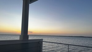 Ein Balkon mit Blick auf das Meer bei Sonnenuntergang.