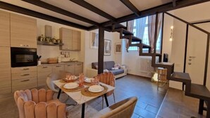 Una sala moderna con comedor, cocina y escalera.
