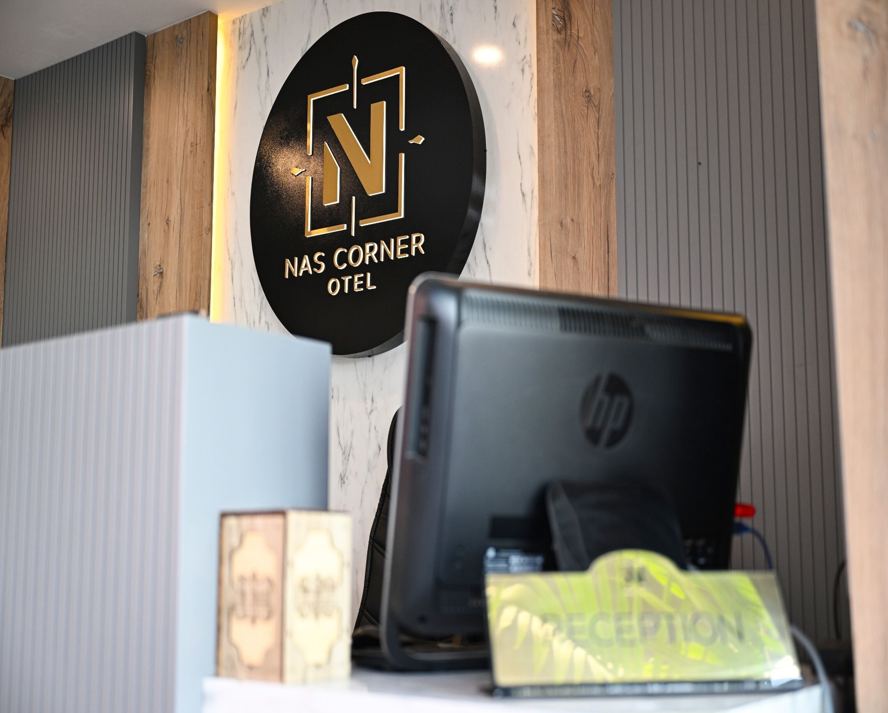 A reception desk with a monitor, a reception sign, and a 'Reception' sign on the desk.