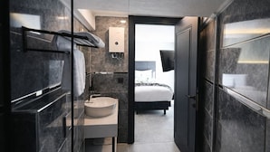 A modern bathroom with a large mirror, a round sink, and a towel rack. - Nas Corner Hotel (Antalya)