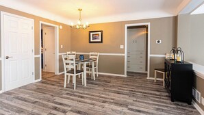 A dining area with a table and chairs, a chandelier, and a black sideboard with candles. - Serene Waterfront Getaway | Patio and Dock (Marysville)