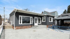 A two-story house with a front porch, a garage, and a covered outdoor area. - Serene Waterfront Getaway | Patio and Dock (Marysville)