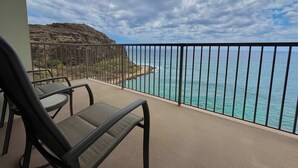 A balcony with two chairs, a view of the ocean, and a rocky landscape. - Marbella Lane -  Beachfront  Haven w/ MT Views! (Waianae)