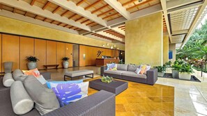A spacious lobby with a modern design, featuring sofas, a coffee table, and potted plants. - Marbella Lane- Prime Watermark Ocean & City View (Honolulu)